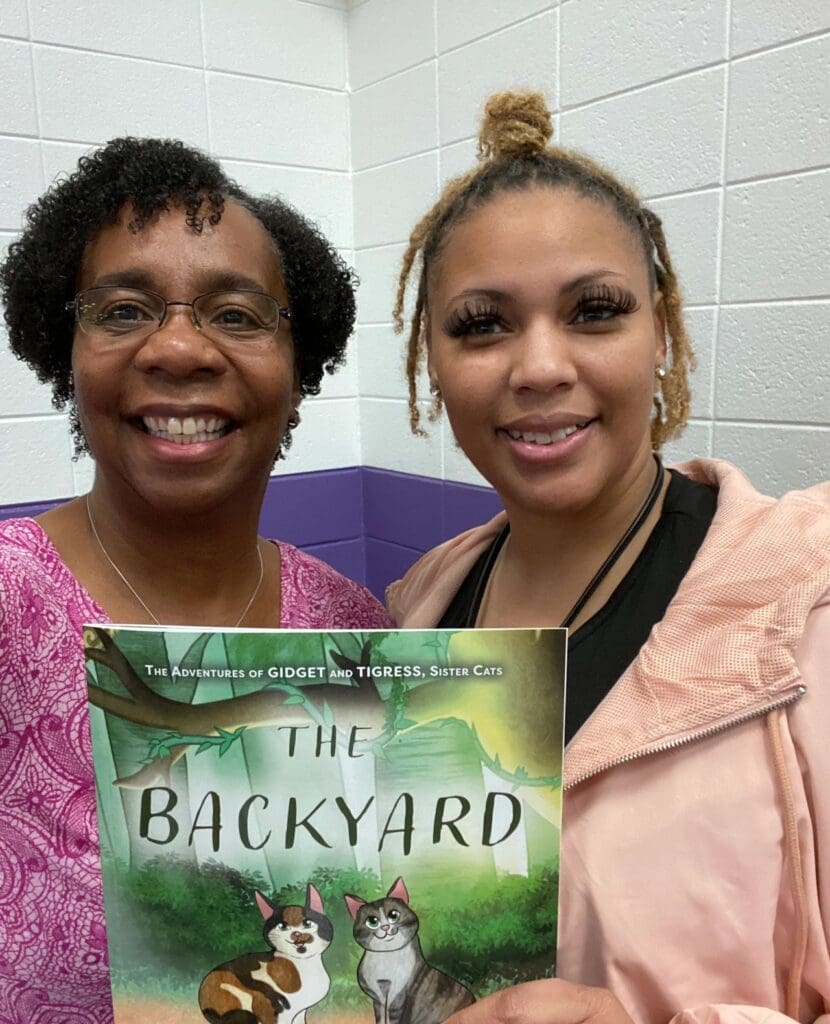 Two women holding a book.