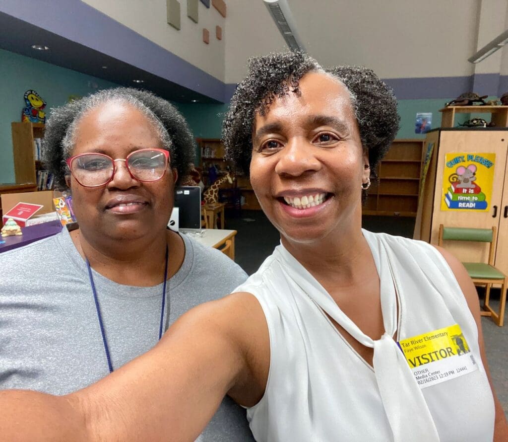 Two women taking a selfie in a library.