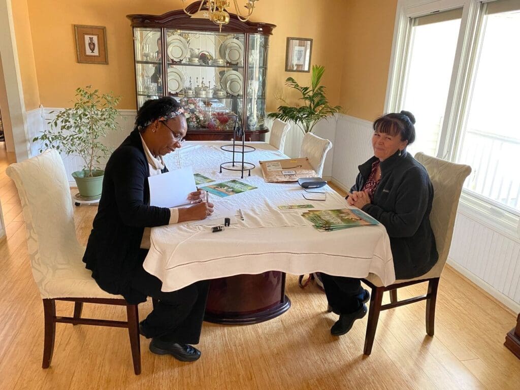 Two women sitting at a table in a living room.