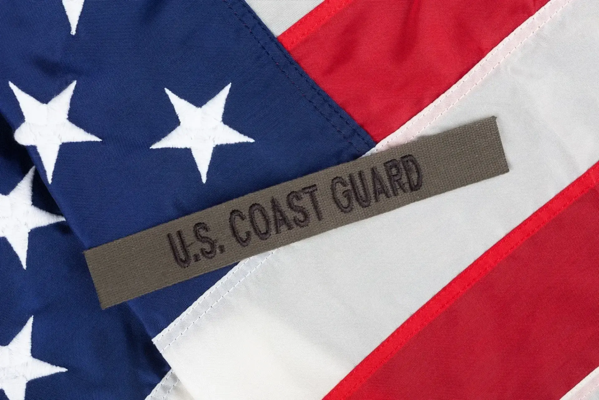 U.S. Coast Guard patch on American flag.