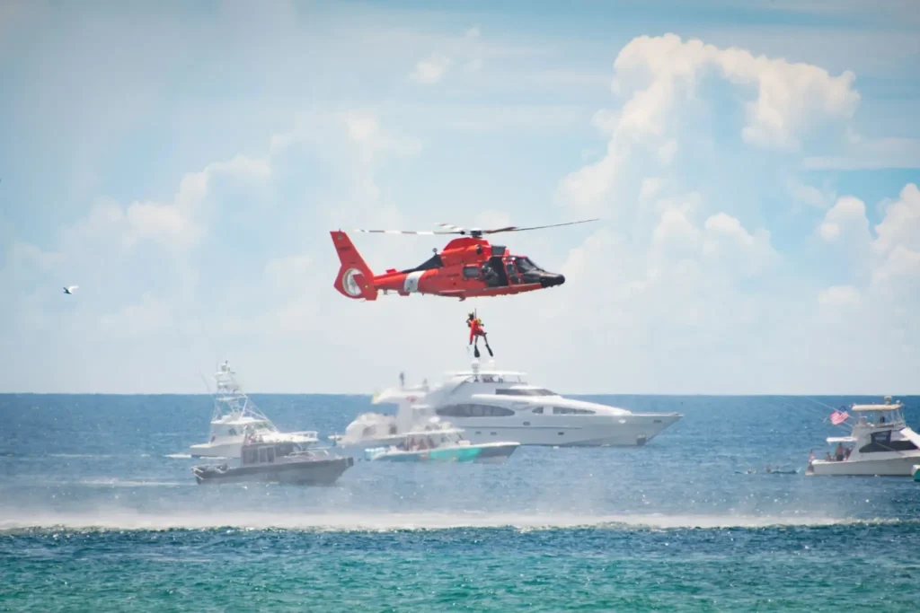 Helicopter rescue over yachts in ocean.