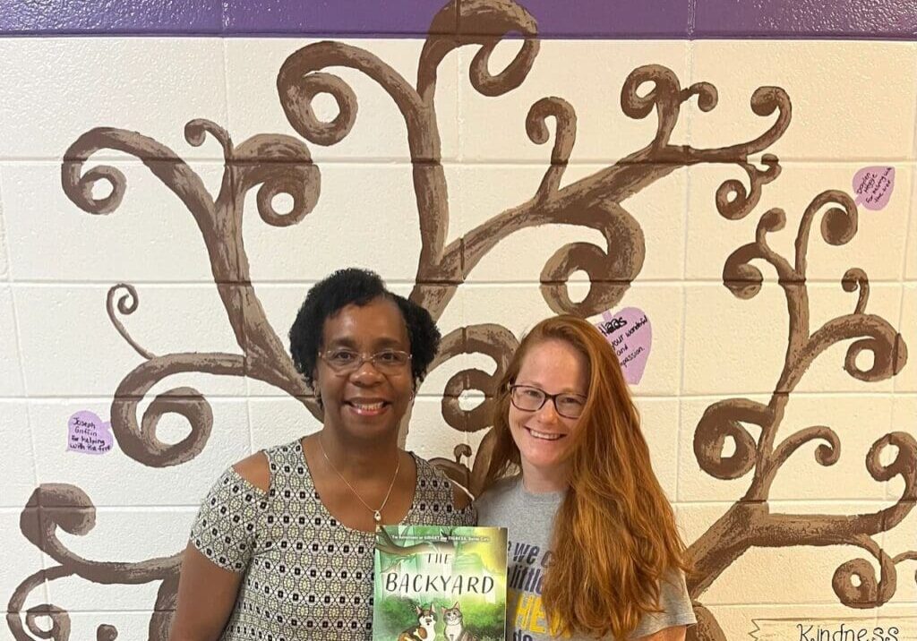 Two women holding a book.