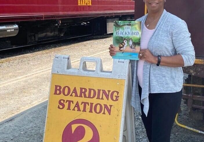 A woman standing in front of a train with a sign for boarding station 2.