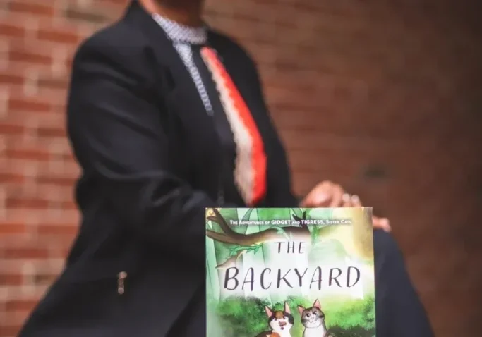 A woman in a suit and tie holding onto a book