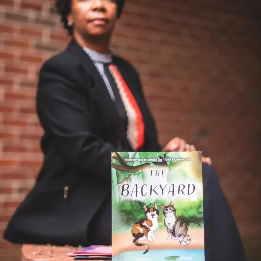 A woman in a suit and tie holding onto a book