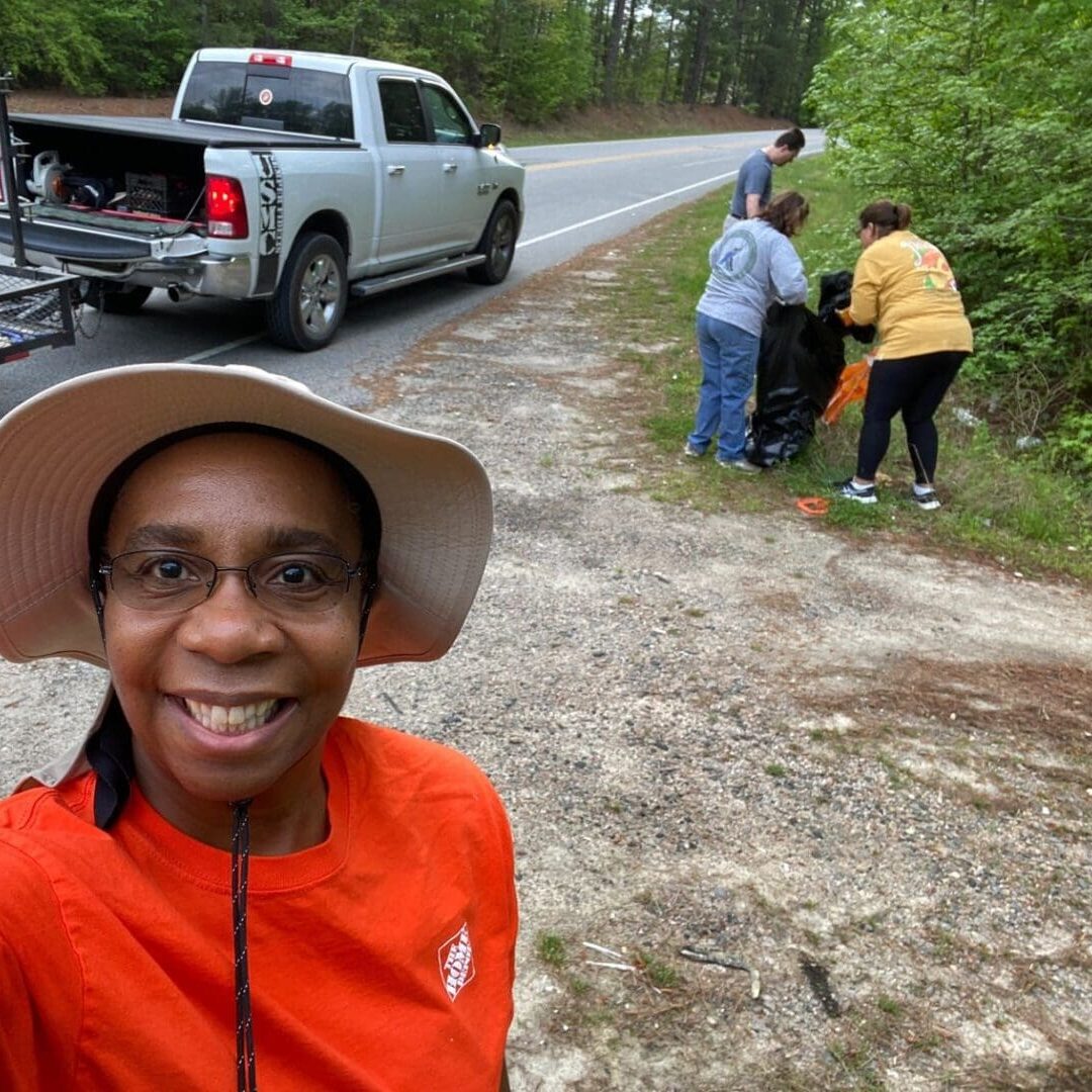 A woman taking a selfie in front of a truck.