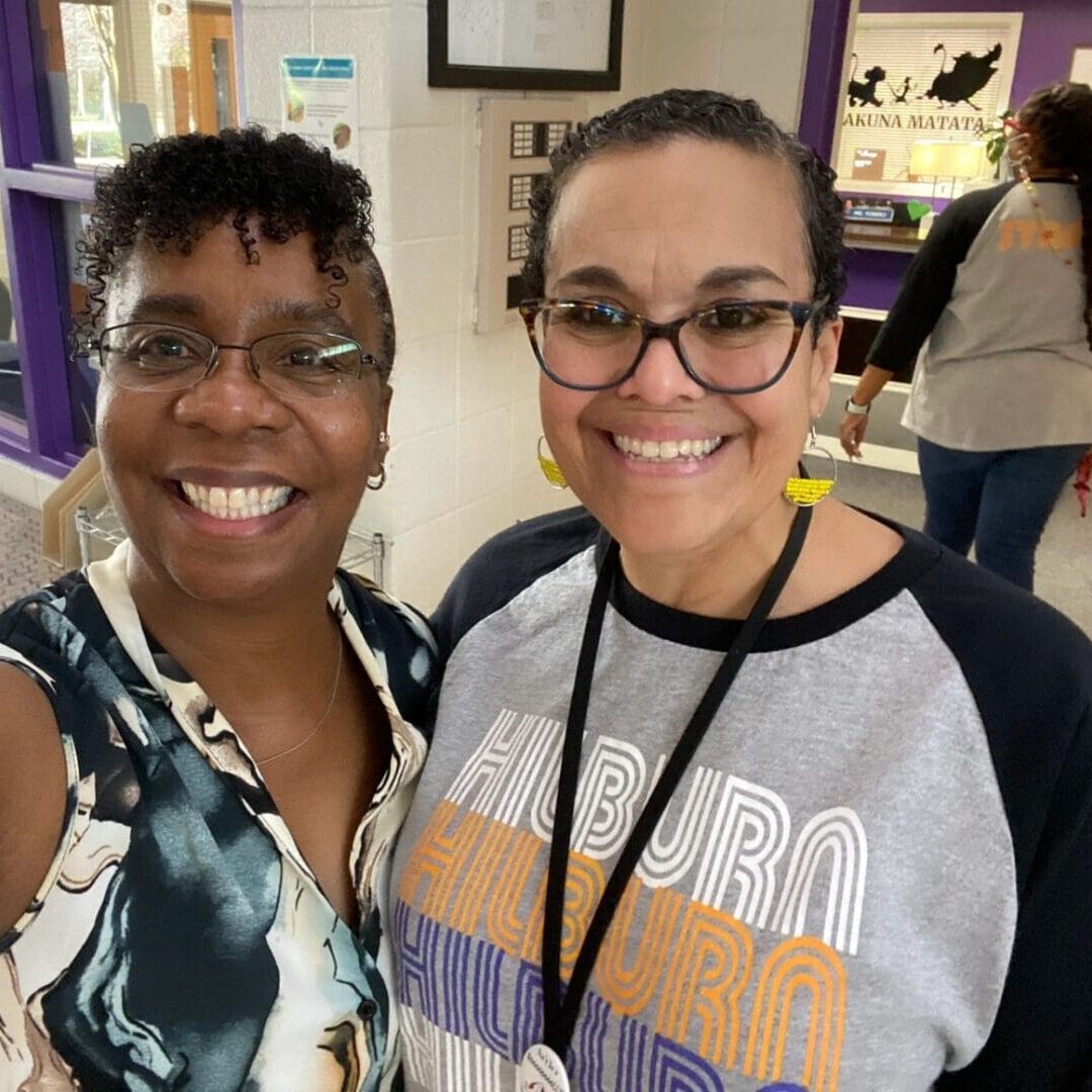 Two women standing next to each other in a hallway.