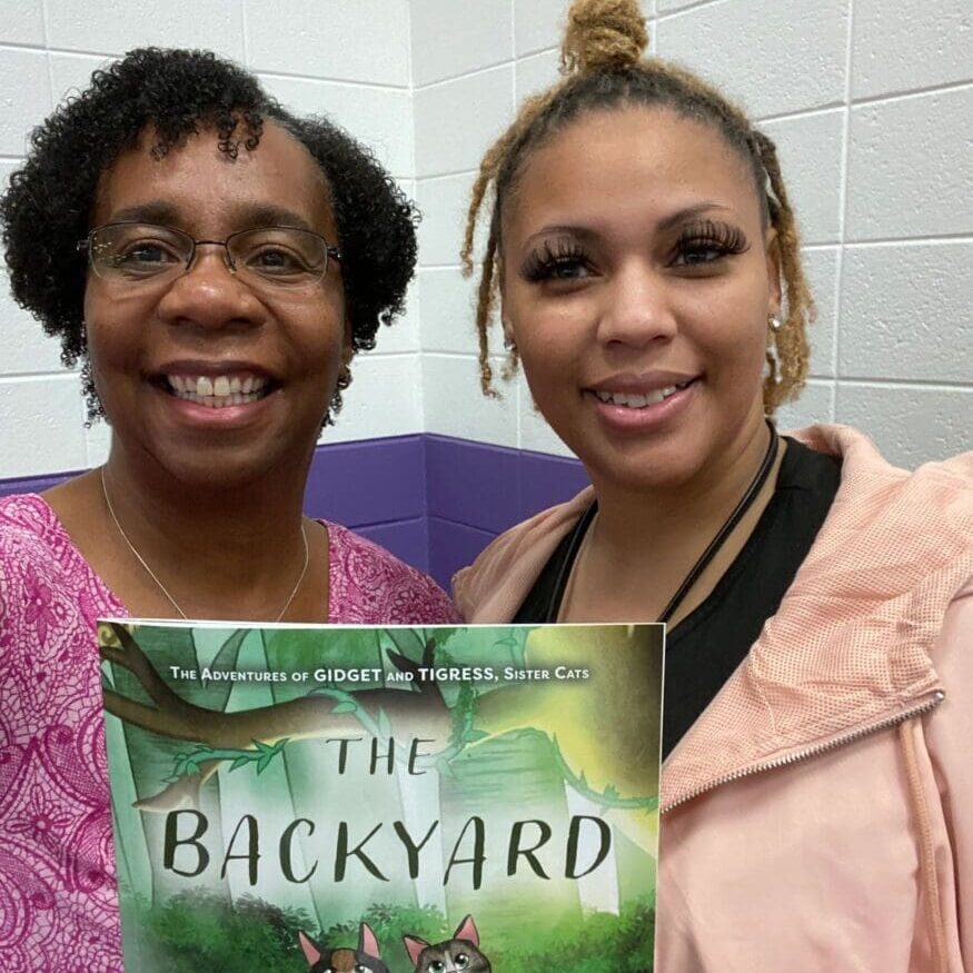 Two women holding a book.