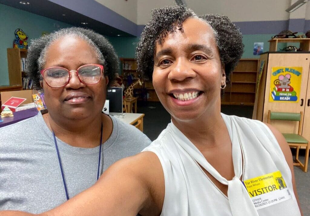 Two women taking a selfie in a library.