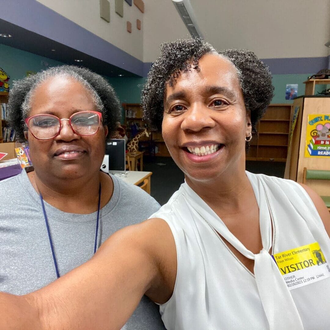 Two women taking a selfie in a library.