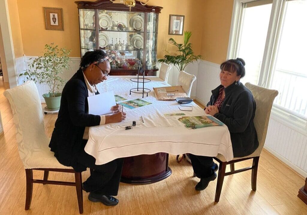 Two women sitting at a table in a living room.